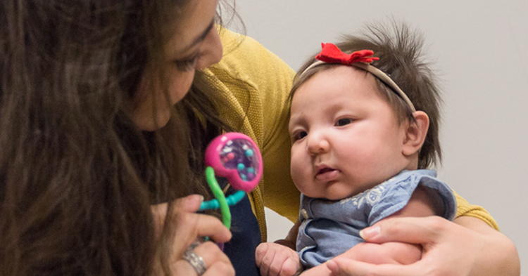 Mother playing with daughter rattle