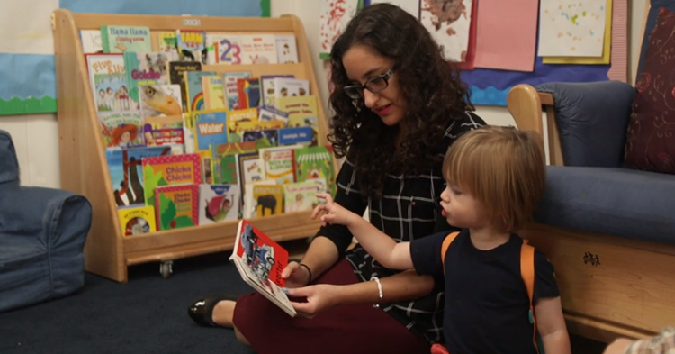teacher reading with child at quality child care program