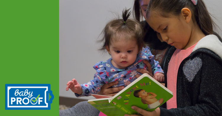 Mom and sister read book with young girl