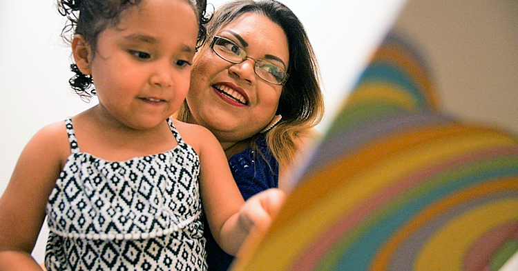 Family working on language and early literacy by reading