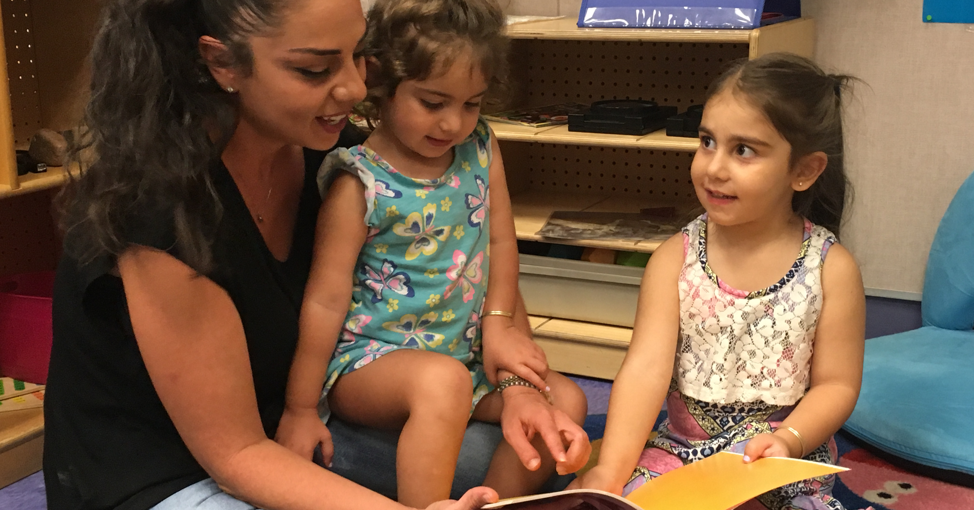 Mom reading with two daughters