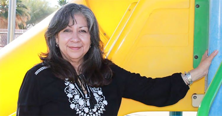 Esther standing in front of a children's playground