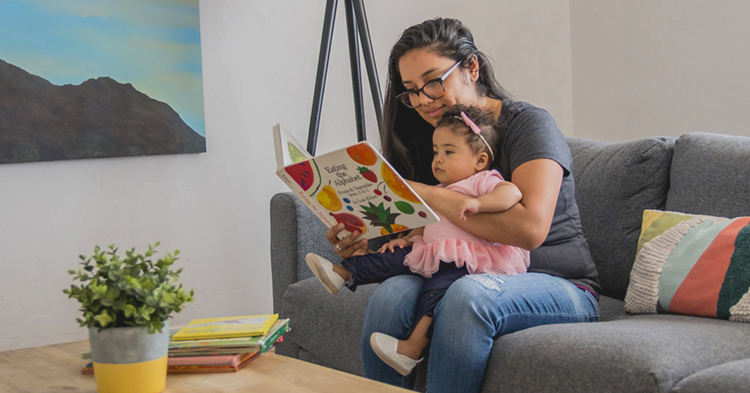 mom reading book to baby