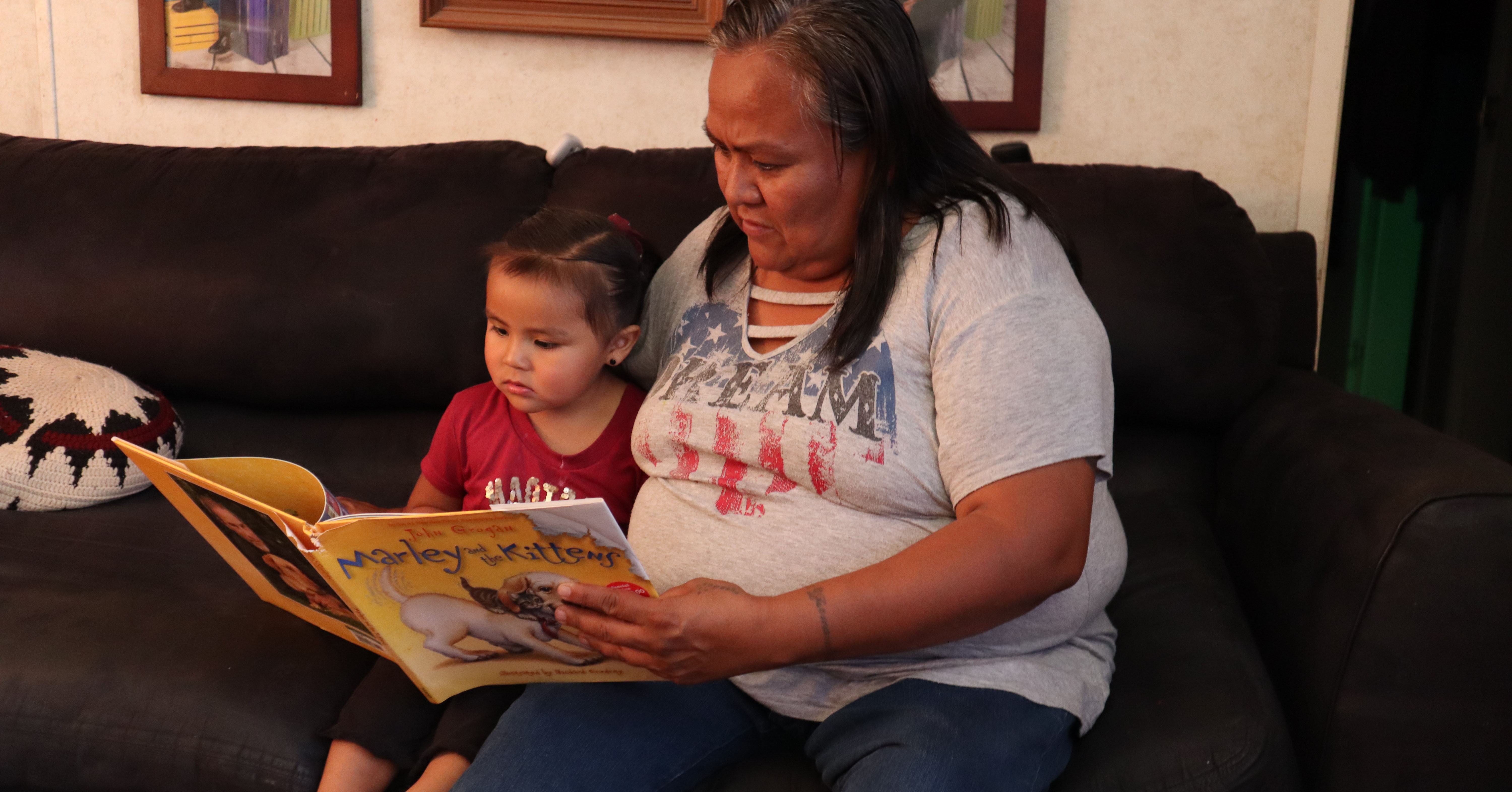 Mother reading with daughter on the couch