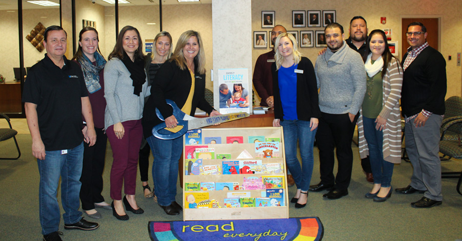 Group of people standing around book display at AEA Credit Union