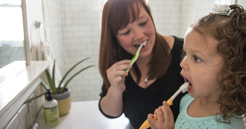 Mom and daughter brushing teeth