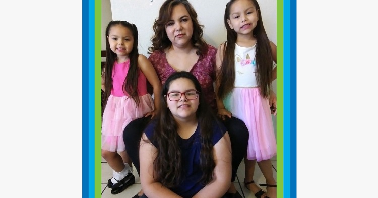 Mom smiling with her three daughters around her