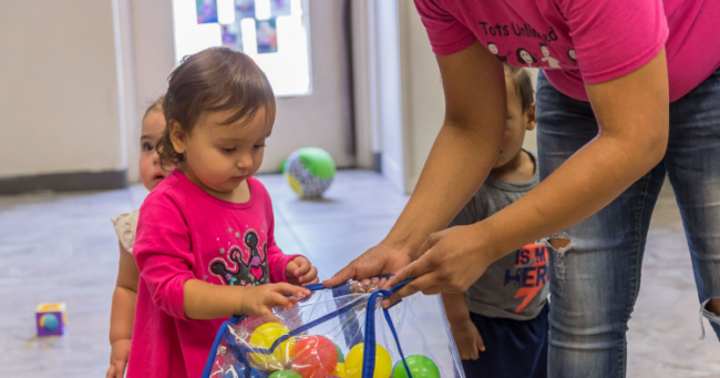 Toddler playing with balls at child care center