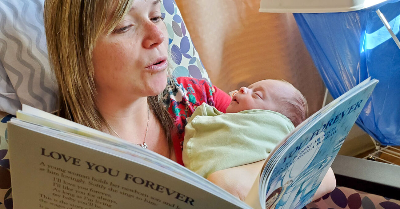 reading corner for babies, mom reading book to newborn baby