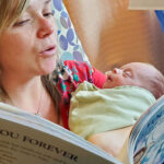 reading corner for babies, mom reading book to newborn baby