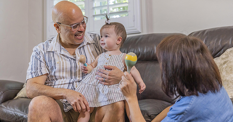 Grandfather with baby on his lap and grandmother sitting nearby