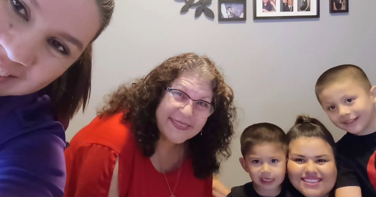 Grandmother, mother and two small children looking at the camera.