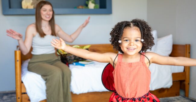 Mom playing with toddler daughter dressed up as a ladybug