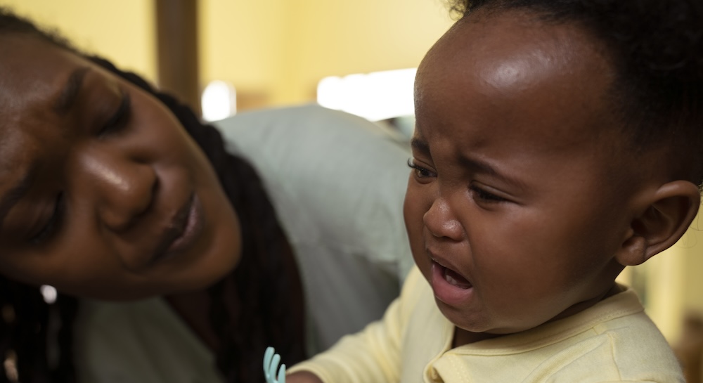 Toddler crying with mom helping calm them down