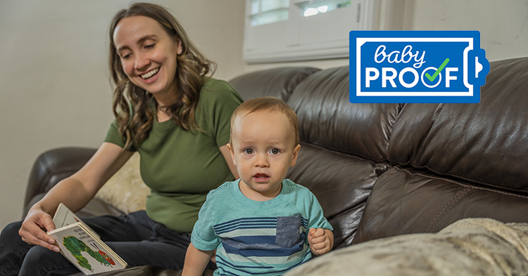 mom reading to toddler on brown couch