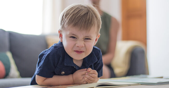 toddler boy in blue shirt making a funny face