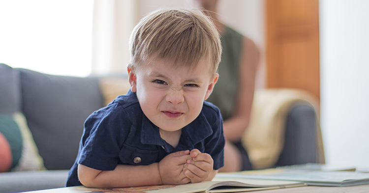 toddler boy in blue shirt making a funny face